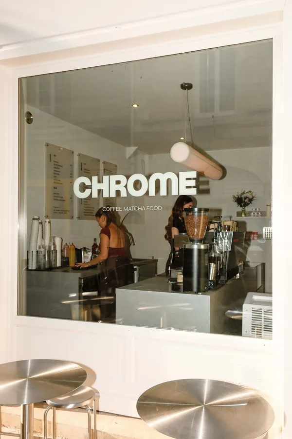 Vitrine du café avec le logo Chrome et l'équipe derrière le comptoir