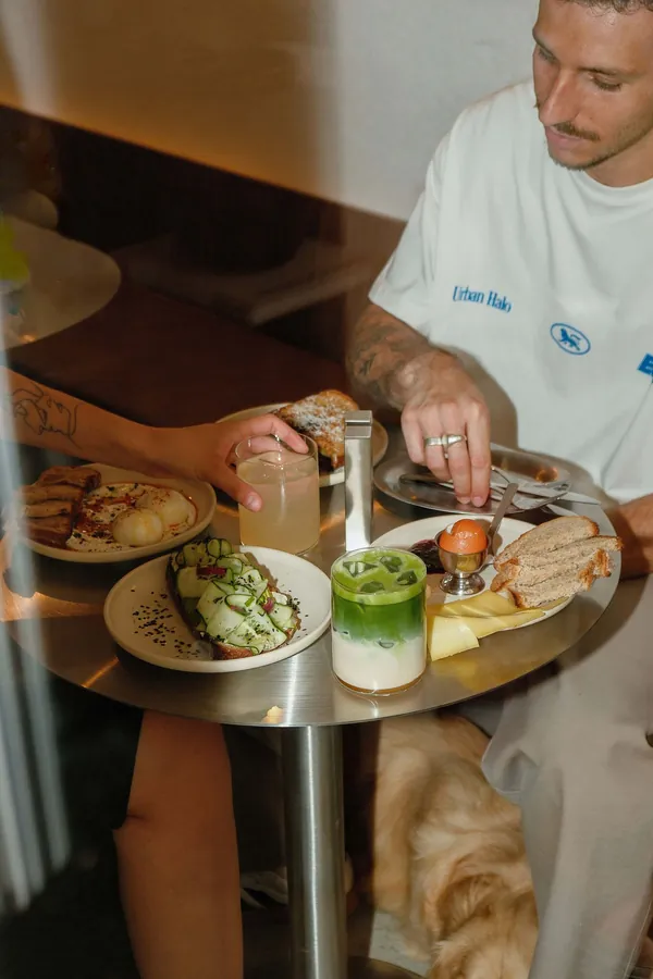 Brunch et matcha latte glacé servis sur une table en inox