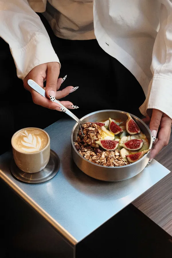 Bol de granola aux figues et cappuccino avec latte art