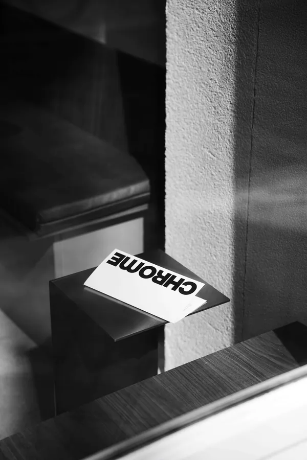 Carte Chrome posée sur une banquette, en noir et blanc