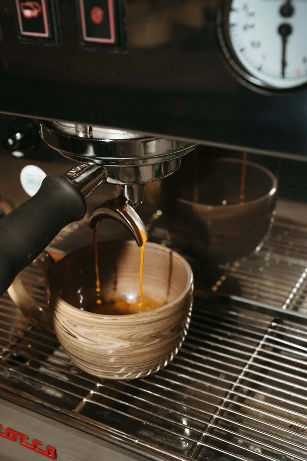 Espresso qui coule de la machine dans une tasse en céramique