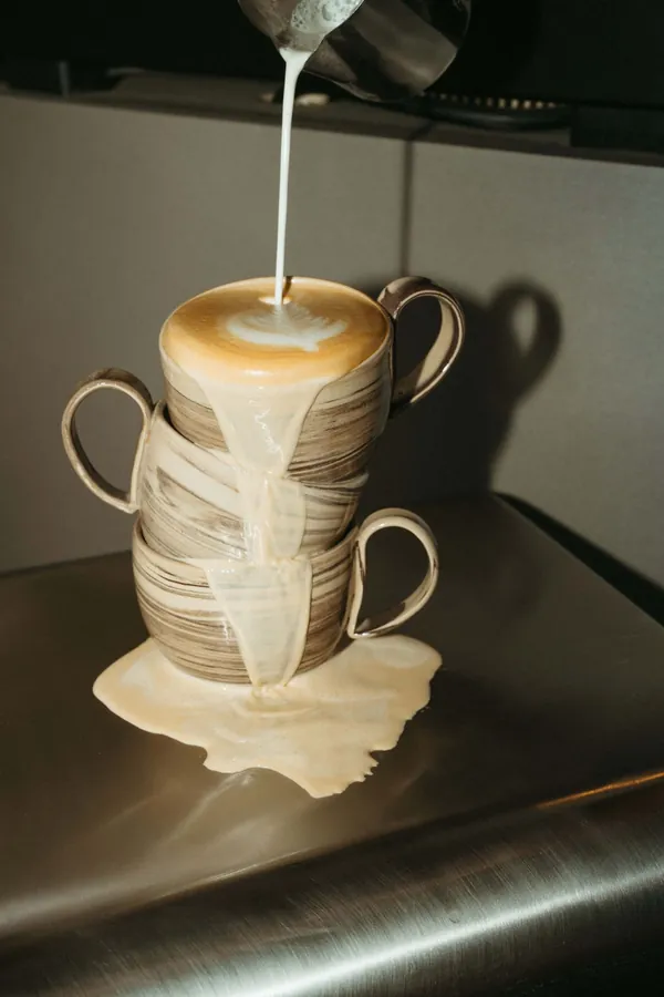 Lait versé sur une pile de tasses qui déborde